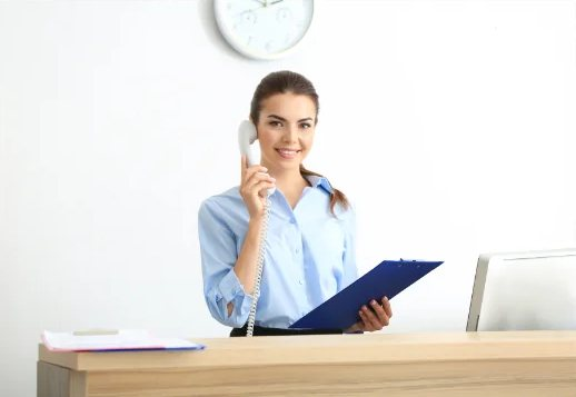 A clinician taking a call at her desk